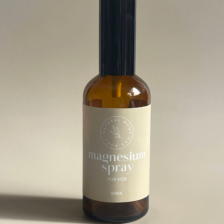 Magnesium oil spray bottle with a beige product label on a beige backdrop.