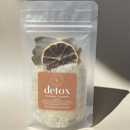 75g 'detox' magnesium bath salts on display on a coloured background with the sun as natural lighting.