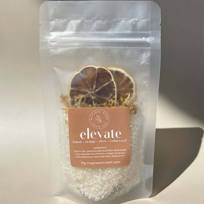 75g 'elevate' magnesium bath salts on display on a coloured background with the sun as natural lighting.