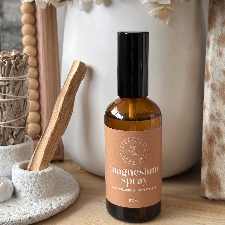 Bottle of magnesium spray on a wooden surface with decorative items in the background